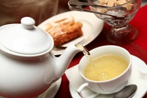 tetera y taza con té en una mesa